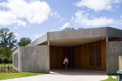 Alejándonos de la esquina, aparece el amplio espacio para poner el auto bajo techo. La pared con rajas cierra un pequeño jardín al que dan los cuartos secundarios.