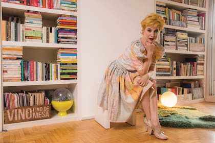 Alejandra en el living delante de una amplia biblioteca repleta de libros que tiene perfectamente visualizados y leídos. “Ordenar es uno de mis verbos preferidos”, admite.