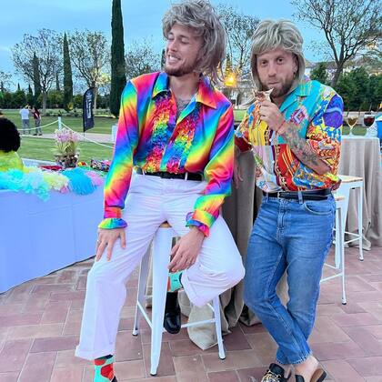 Alejandro "Papu" Gómez y Lucas Ocampos disfrazados con camisa multicolores y pelucas rubias