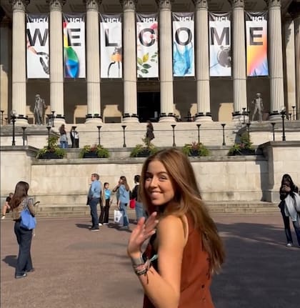 Alexia saluda a la cámara en su ingreso a al facultad