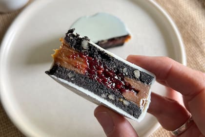 Alfajor de chocolate relleno con dulce de leche y corazón de frutos rojos.