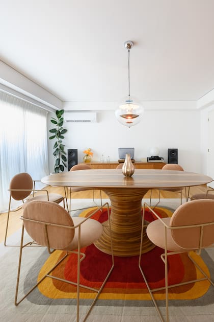 Alfombra de lana patagónica hecha a pedido (JT. Pfeiffer). Mesa (BoConcept) con obra del orfebre Emiliano Céliz. Sillas 'Almendra' (Bull). Lámpara de techo 'VP Globe' del diseñador danés Verner Panton.