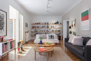 En el estar, biblioteca con estructura metálica y estantes de paraíso macizo diseñada por el estudio Alonso-Crippa. Alfombra de yute, sofás (Ikea), mesitas ‘Danesa’ (Broca Muebles) y lámpara de pie (@mrsolson.ba).
