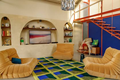 Alfombra diseñada por Eme Carranza Studio y tejida por Mooody Rugs. Sillones ‘Togo’ (Landmark). Mesa de arrime italiana. Lámpara colgante (Eme Carranza).