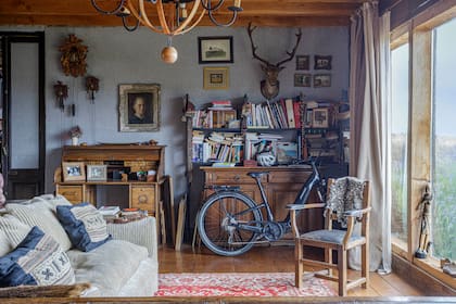 Alfombra persa, sofá con almohadones tejidos, pieles locales, muebles heredados y tantísimos libros.