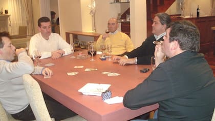 Alfredo Lijo (en la cabecera, de frente) junto a su hermano, el juez Ariel Lijo (camisa negra, de perfil), quien fuma un habano mientras juegan al truco