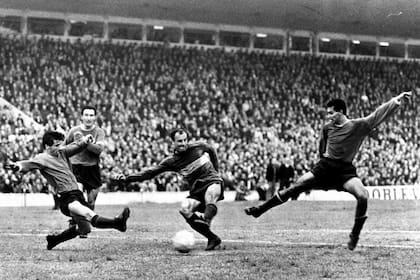 Alfredo Rojas le convierte un gol a Independiente en la Doble Visera, superando el cruce de Pipo Ferreiro; observan Hacha Brava Navarro y David Acevedo