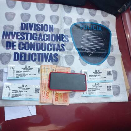 Algunas de las entradas, el dinero y el teléfono celular que incautó la Policía de la Ciudad