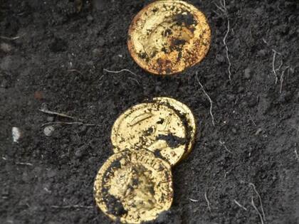 Algunas de las monedas de oro junto a las víctimas