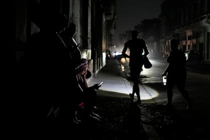 Algunas personas caminan por la calle durante un apagón general el viernes 14 de marzo de 2025, en La Habana, Cuba