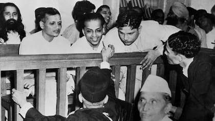 Algunos de los acusados hablan con sus abogados defensores antes de su juicio por el asesinato de Gandhi; de izquierda a derecha están Nathuram Vinayak Godse, Narayan Dattatraya Apte, Vishnu Rama Krishna y el hombre barbudo en la segunda fila es M. Badge