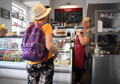 Alison Larmont atiende a un cliente en su café, en el centro de la ciudad de Keswick, en el Distrito de los Lagos, al noroeste de Inglaterra, el 20 de junio de 2022.