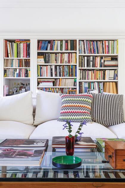 Almohadones de Missoni y Jonathan Adler. La alfombra rayada de Ikea suma a través de la tapa de vidrio de la mesa baja.