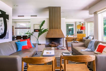 Almohadones de Plain Textiles, la marca deco de Valeria que se especializa en estampas serigrafiadas sobre tela. Mesa de centro de cemento y resina (Silvina Apás), sillas (Zeta Concept Store). Obra en blanco y negro de Lisy von Zehmen.