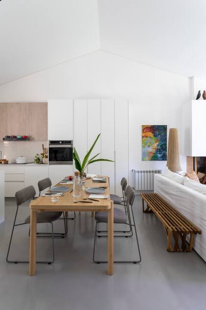 Alrededor de única mesa ‘de la casa (el modolo 'Elo’ de El Yeite), sillas ‘Ply’ (Cúmulo). Banco largo de madera (La Base Studio). El cuadro, obra de la dueña de casa, la arquitecta Sara Plazibat.