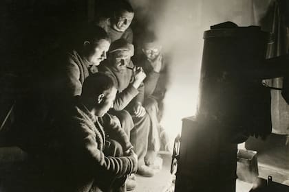 Alrededor del fuego del vigilante nocturno durante la Expedición Imperial Transantártica, 1914-17, dirigida por Ernest Shackleton. (Foto de Frank Hurley/Scott Polar Research Institute, Universidad de Cambridge/Getty Images)