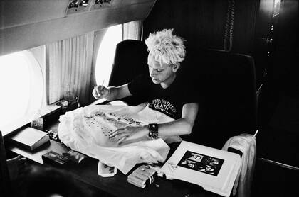 ALTO VUELO Gore autografía una remera en un avión hacia Pasadena, California, donde el director D.A. Pennebaker filmó 101, su película de 1989. Corbijn tenía vía libre para fotografiar a la banda en sus viajes. "No soy un tipo de estudio-aclara-, soy más de buscar momentos".