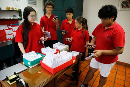 Alumnos del Colegio Belgrano Uno, en Núñez, guardan los celulares antes de la clase