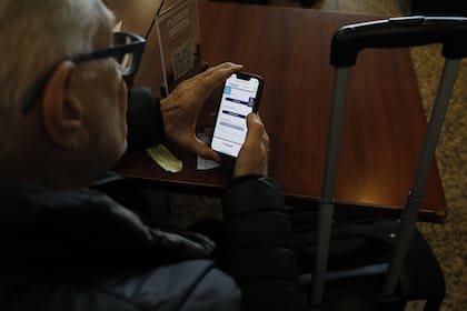 Amadeo, de 82 años, intenta reprogramar su vuelo por la aplicación del celular de JetSmart