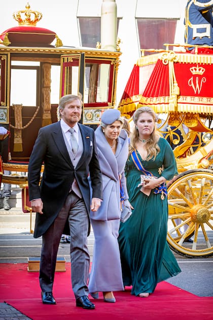 Amalia armó su look con un vestido de gasa verde botella, de escote en V, con falda volada y mangas de murciélago de la maison Asos. Usó un tocado de Fabienne Delvigne, la sombrerera preferida por su madre, y un clutch con pedrería de la marca Anna Cecere Bags. Eligió zapatos de tacos altos color nude de Gianvitto Rossi y guantes en el mismo tono.