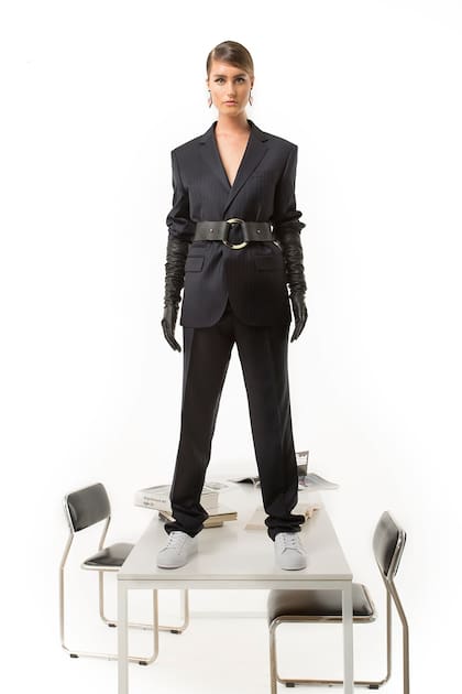 Ambo rayado (Raimondi), cinturón ancho de cuero con hebilla redonda (Las Pepas), zapatillas de cuero (Adidas), aros geométricos espejados (Iskin Sisters), guantes de cuero (Carpincho)