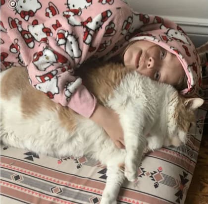 Amelie, de 10 años, con Axel, el gato que adoptó su familia