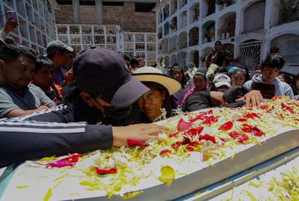 Amigos y familiares lloran durante el funeral de José Luis Aguilar, de 22 años, que murió en los enfrentamientos entre manifestantes y las fuerzas armadas en un intento de tomar el aeropuerto de la ciudad el 15 de diciembre, en la ciudad andina central de Ayacucho, Perú, el 18 de diciembre de 2022.