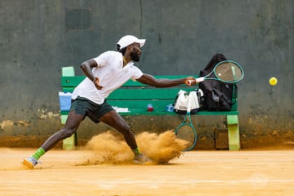 Amoako Boafo se desliza para alcanzar una pelota lateral durante un torneo en Ghana