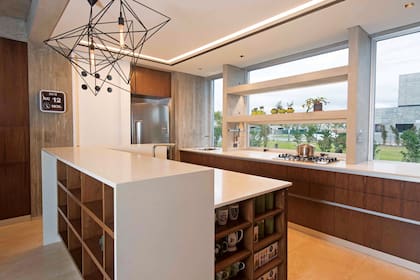 Amoblamiento de cocina de incienso con mesadas ‘Igneastone Classical White’ (Marmolería Itatí). En la cocina, los 60cm estándar de mesada se llevaron a 85. Además de sumar espacio, la disrupción permitió incorporar un extractor que se guarda detrás del anafe, lo que libera la vista.