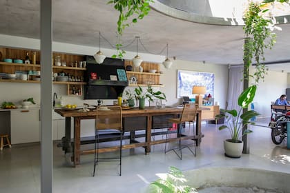 Amoblamiento de cocina en MDF laqueado con estantes de pino tea recuperada. La barra es una vieja mesa de taller encontrada en una compraventa de Tigre.