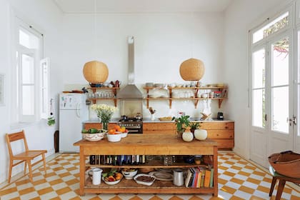 Amoblamiento de cocina en pino tea recuperada, mesada de mármol de Carrara (El Progreso Marmolería Mecánica), artefacto de 6 hornallas (Whirlpool), campana industrial (Teknoventilación) y mesón de madera (Rajatabla).