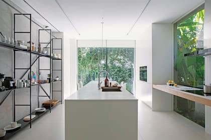 Amoblamiento de cocina, estantería de hierro (Estudio LDMB), mesada en cuarzo ‘Pure White’ de Caesarstone (Calello Hermanos) con pileta empotrada ‘Planar’ (Franke), canilla ‘Focus’ (Hansgrohe) y cepillo redondo de bambú ‘Bubble up’ (Park Design). Cortinas roller (Riel Americano).