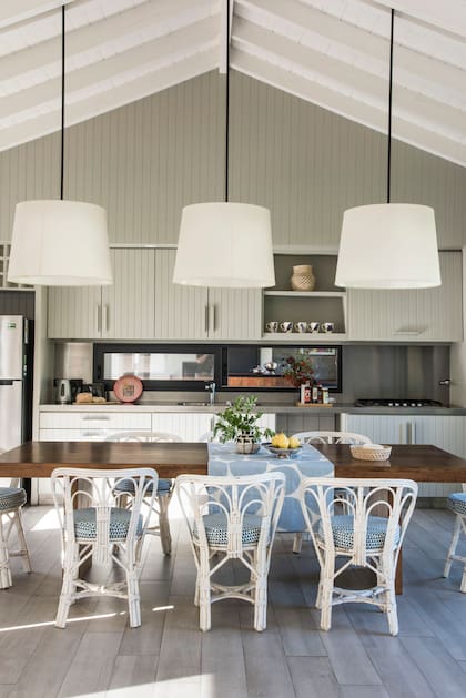 Amoblamiento de madera en bastones laqueados color verde musgo, diseño del estudio Mazzinghi-Sánchez. Rodeando la mesa, las icónicas sillas Mar del Plata