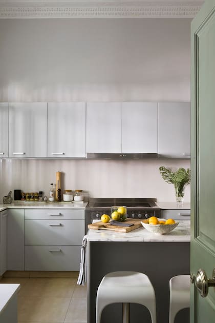 Amoblamiento en MDF laqueado (Estudio Planta). Mesadas de Ultraquartz ‘Blanco Alpino’ (Mármoles Anton); la de la isla se hizo con mármol Arabescato.