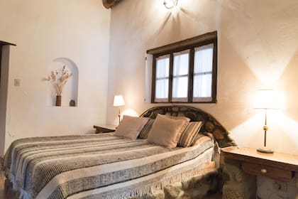 Amplia habitación con detalles en piedra y techos altos, de la hostería de Finca El Carmen.