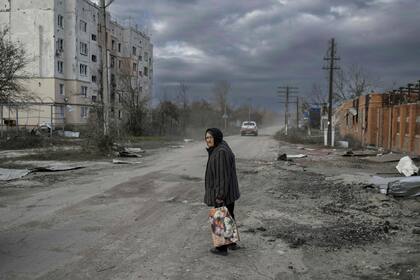 An old woman walks in the Kherson region village of Arkhanhelske on November 3, 2022, which was formerly occupied by Russian forces. (Photo by BULENT KILIC / AFP)