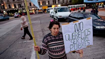 Ana Paz protesta con un cartel frente a la olla popular ubicada en la Plaza del Congreso
