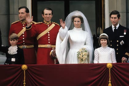 Ana y Mark Phillips en el balcón del Palacio de Buckingham tras la primera boda de la princesa, el 14 de noviembre de 1973. A la derecha de la imagen, el hermano de la novia, Carlos, por entonces príncipe de Gales. Los niños son su hermano menor, el príncipe Eduardo (hoy duque de Edimburgo), y su prima Sarah Armstrong-Jones (hoy Sarah Chatto), hija de la princesa Margarita. 