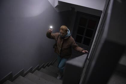 Anastasia Pyrozhenko, de 25 años, sube a oscuras las escaleras de su edificio de apartamentos de varias plantas en Kiev, Ucrania, el domingo 20 de noviembre de 2022. 