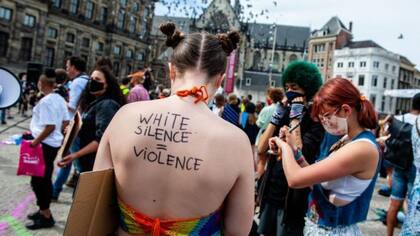 "El silencio de los blancos es violencia", se lee en la espalda de esta manifestante