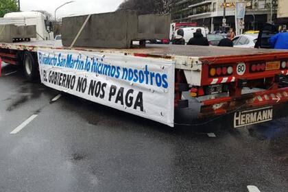 "El viaducto lo hicimos nosotros y el gobierno no nos paga" dice el cartel de uno de los camiones estacionados sobre la avenida"