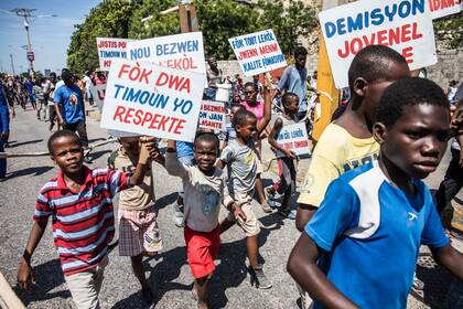 &quot;Los derechos de los niños deben ser respetados&quot;, dice el cartel de un niño haitiano durante la protestas que exigen la dimisión del presidente Jovenel Moïse