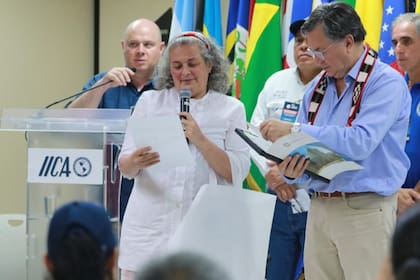 Andrea Izzo-Capella mientras entrega un reconocimiento que envió el municipio a Manuel Otero, director general del IICA 