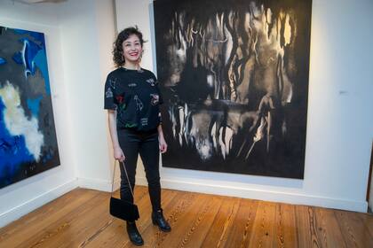 Andrea Lamas pinta en dos colores, azul y rojo, y crea pinturas que se asoman a misterios