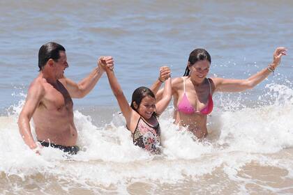 Andrea, su nieta Olivia y Lucas se divierten saltando las olas en La Brava de José Ignacio.