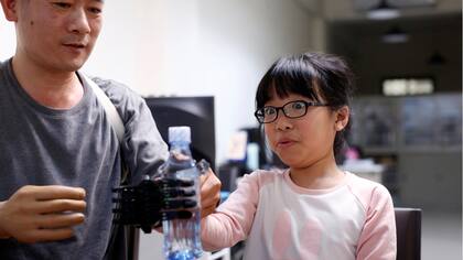 Angel Peng, de 8 años, durante las pruebas de su mano impresa en 3D diseñada y construida por el ingeniero Chang Hsien-Liang, en Taoyuan, Taiwan.