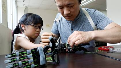 Angel Peng, de 8 años, durante las pruebas de su mano impresa en 3D diseñada y construida por el ingeniero Chang Hsien-Liang, en Taoyuan, Taiwan.