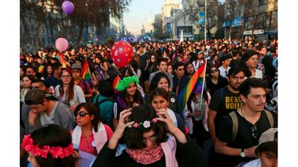 Angela, debajo del centro, coloca una corona de flores en su cabeza mientras asiste a una marcha del Orgullo Gay junto a otros niños transgéneros en Santiago, Chile