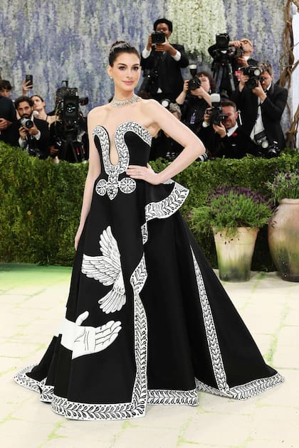 Anne Hathaway dijo presente con un glamoroso diseño en negro y blanco. Su original escote y las estampas de su falda que recrean la liberación de un pájaro acapararon todos los flashes