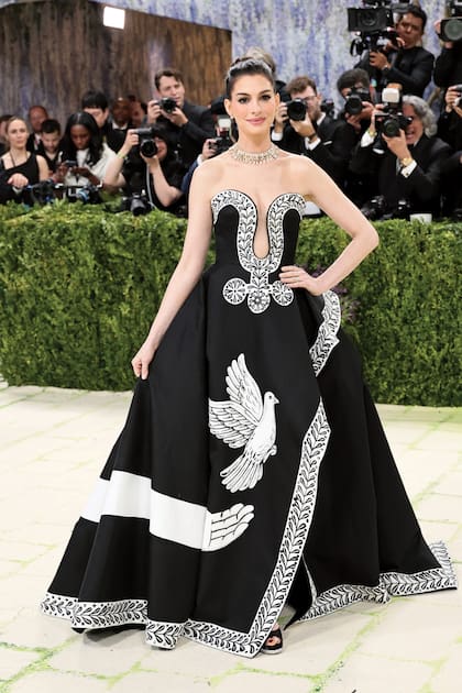 Anne Hathaway eligió un diseño en seda mikado de Michael Kors en colaboración con el artista Peter McGough, que intervino la falda con
flores, palomas y detalles de la Grecia clásica.
Está inspirado en el poema Oda a una urna griega, de John Keats